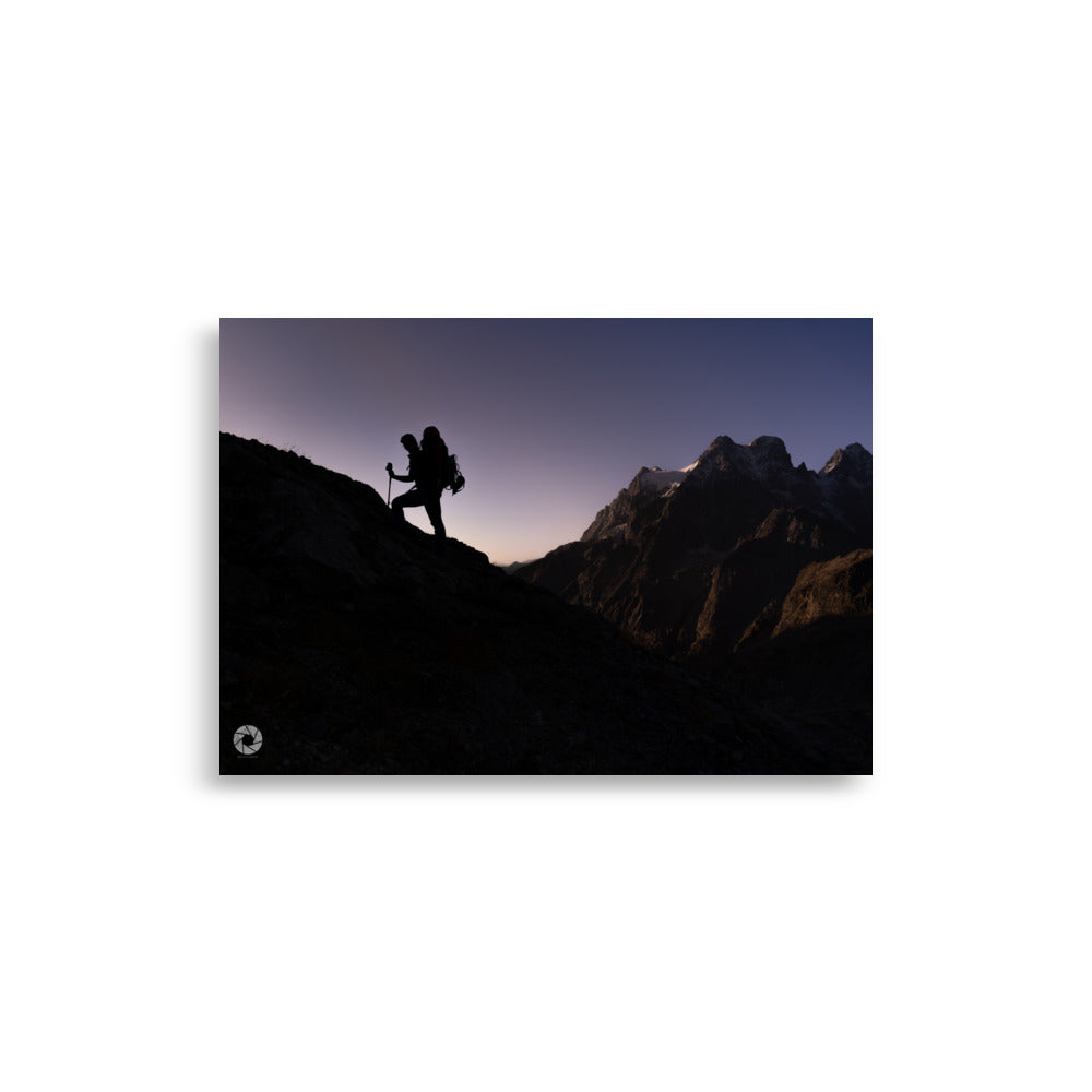 Photographie d'un randonneur progressant sur une montagne au crépuscule, capturée par Brad Explographie, illustrant la beauté et le défi de l'ascension dans un décor montagneux impressionnant.