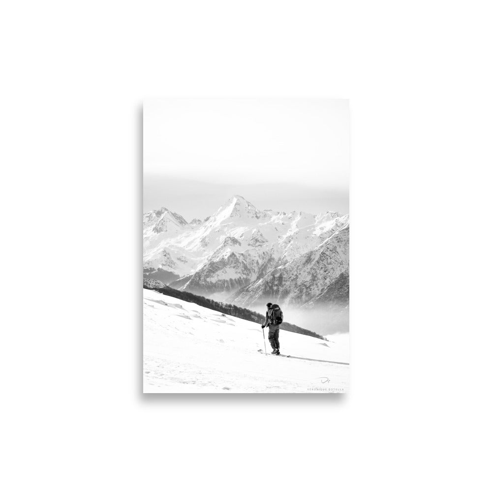 Photographie en noir et blanc d'un randonneur face aux montagnes enneigées, par Véronique Botella, illustrant la majesté et la solitude de la nature.
