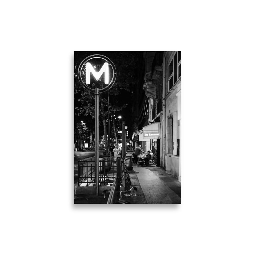Photographie de rue en noir et blanc de "Rendez-vous Nocturne", capturant une scène de terrasse de café nocturne.