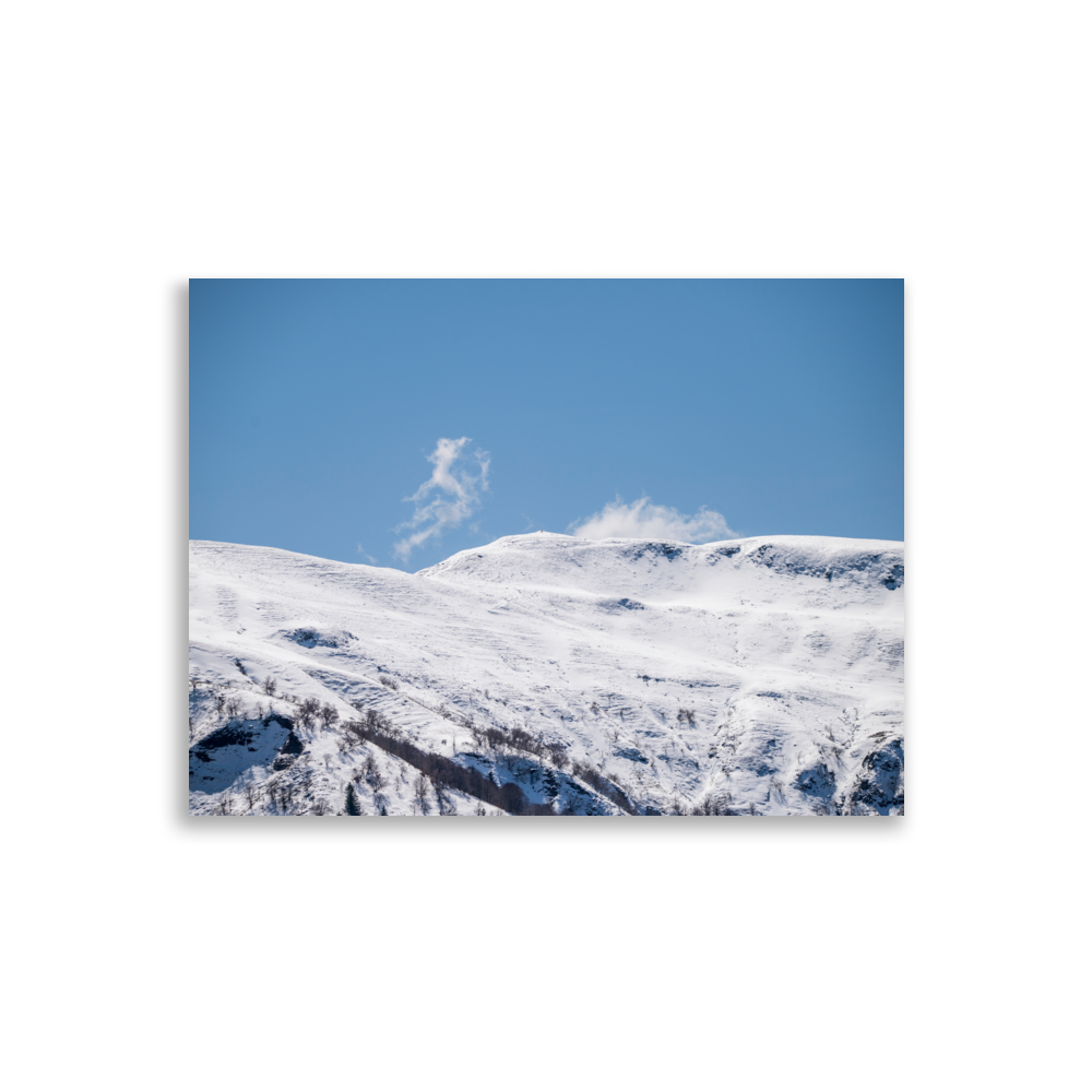 Photographie des montagnes enneigées du Cantal avec un nuage en forme de petit monstre.