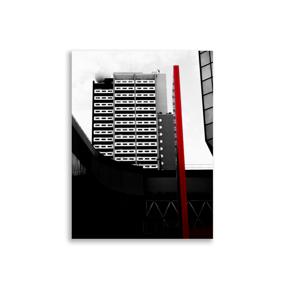 Photographie noir et blanc d'un bâtiment de style vintage des années 60 avec un élément rouge distinctif.
