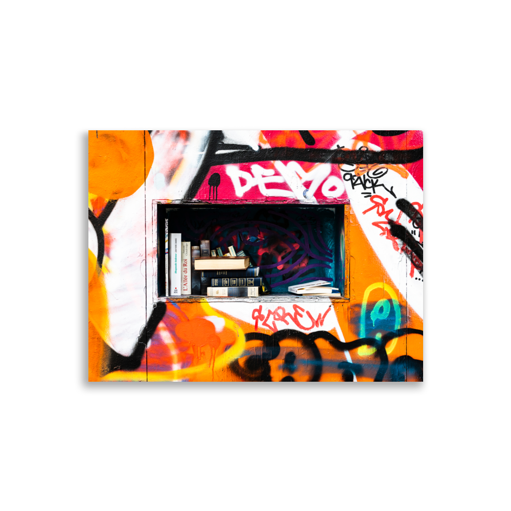 Photographie colorée d'une bibliothèque de partage taguée, située dans une rue.