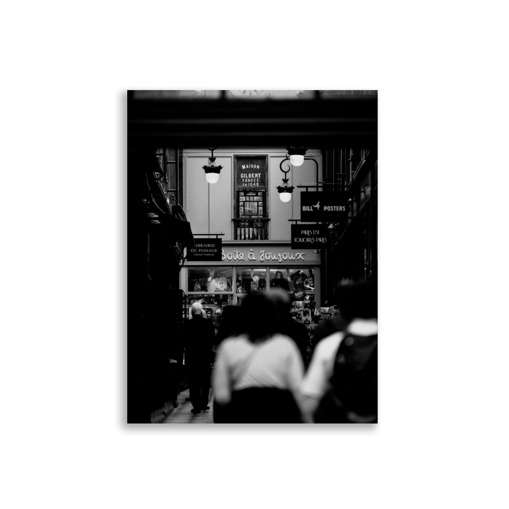 Scène de rue en noir et blanc d'un passage parisien.