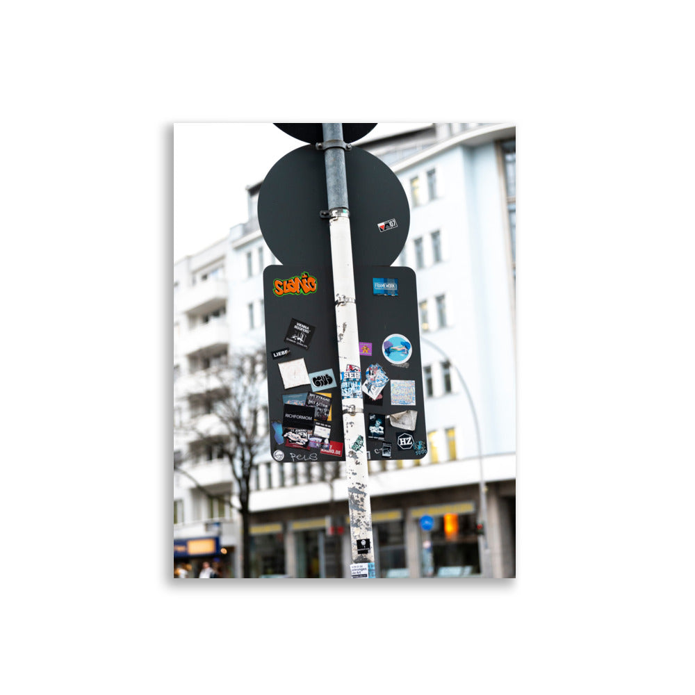 Photographie 'Liebe' dépeignant l'arrière des panneaux de circulation à Berlin couverts d'autocollants avec divers messages.