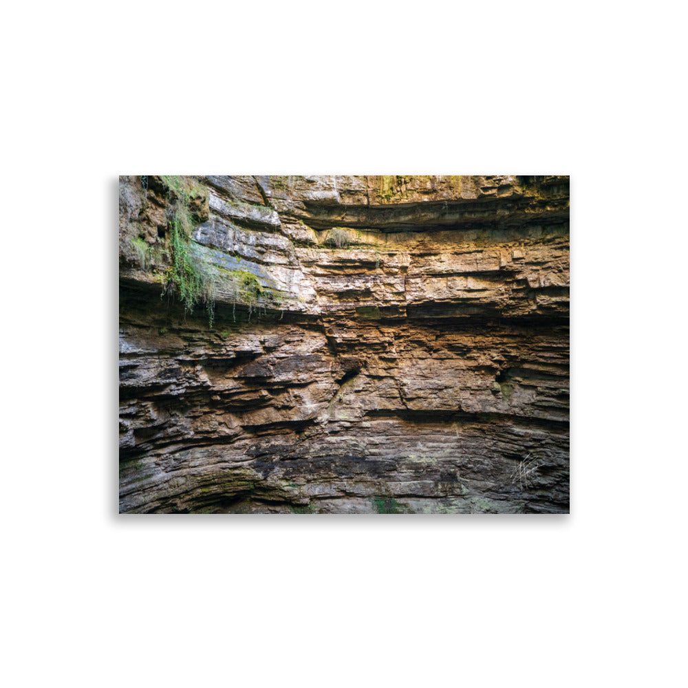 Photographie détaillée d'un mur de roche souterrain au gouffre de Padirac montrant des couches distinctes et des signes d'érosion.