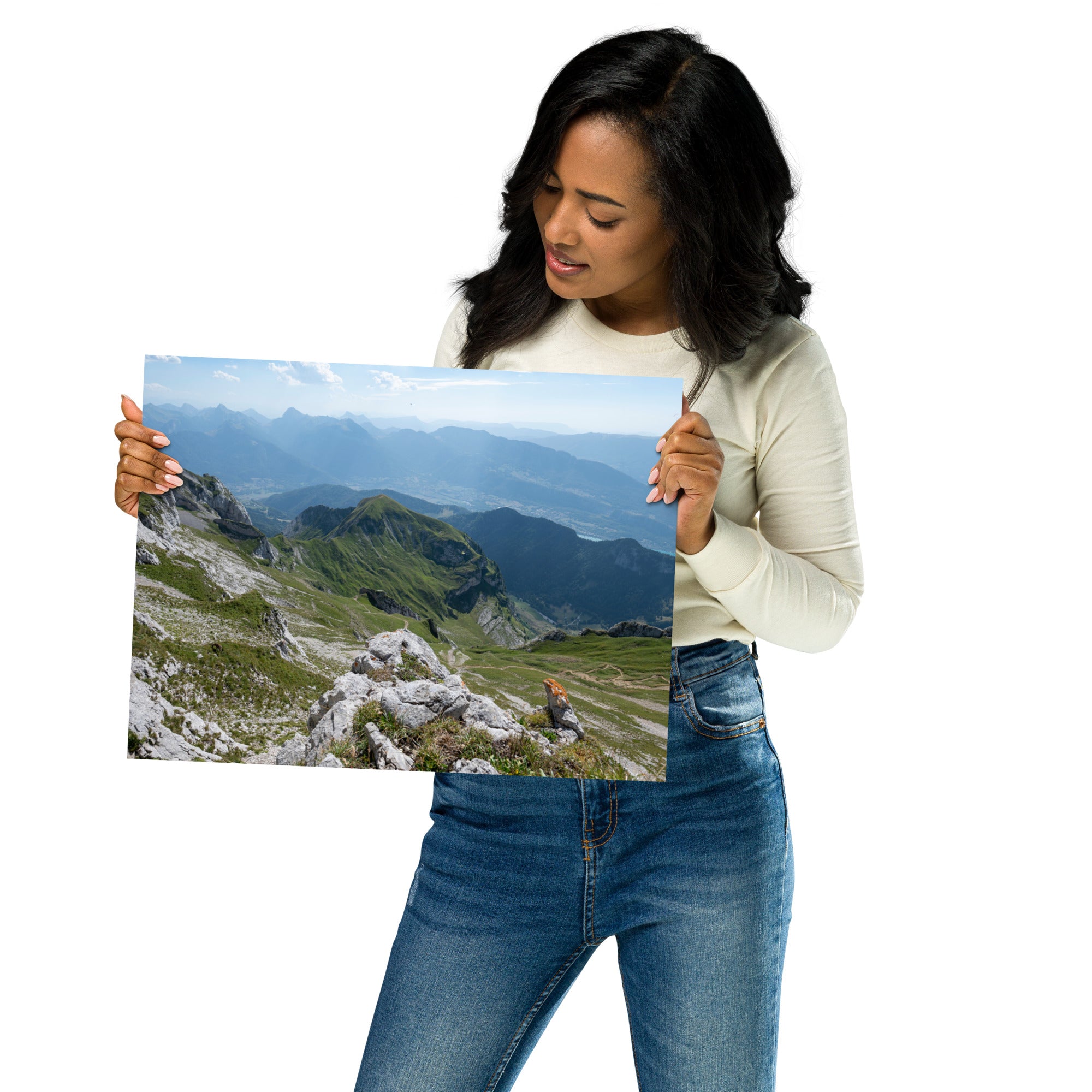 Vue panoramique du lac Annecy depuis les hauteurs, entouré de montagnes majestueuses avec un ciel serein au-dessus. Une représentation fidèle de la beauté naturelle des Alpes.