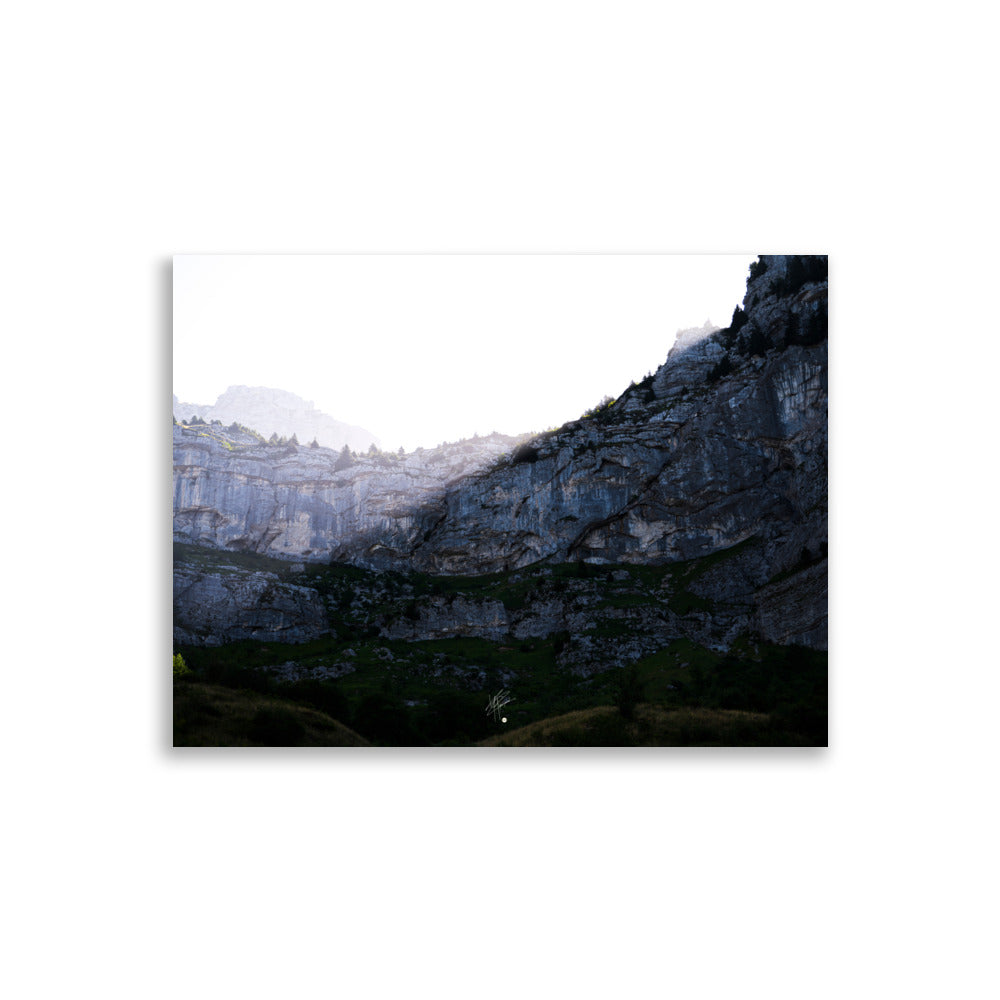 Photographie saisissante du Massif de la Tournette, capturant le moment où les premiers rayons du soleil éclairent la partie supérieure de la montagne et où l'ombre reste en bas.