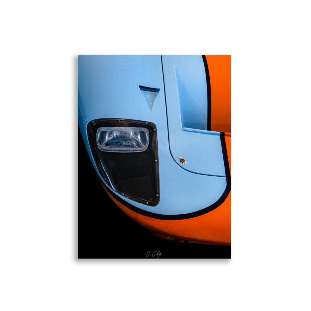 Poster 'GT40 Gulf' capturant la nostalgie de la Ford GT40 à travers un détail du bloc optique vintage et du capot bleu et orange, offrant une plongée visuelle dans l'histoire légendaire des courses automobiles par le photographe Charles Coley.