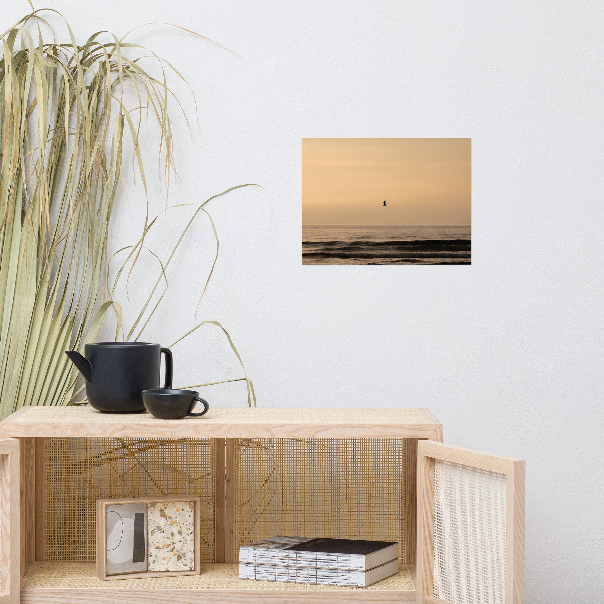 Photographie d'un coucher de soleil en bord de mer avec reflet du soleil sur les vagues, horizon doré et oiseau volant au-dessus de la mer.