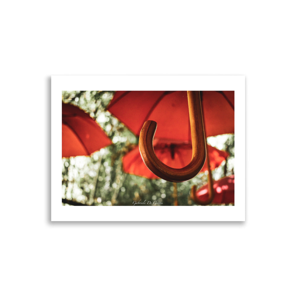 Photographie artistique de parapluies rouges suspendus, capturée par Gabriele de Grossi, offrant un contraste éclatant avec un arrière-plan subtil, évoquant originalité et couleur.
