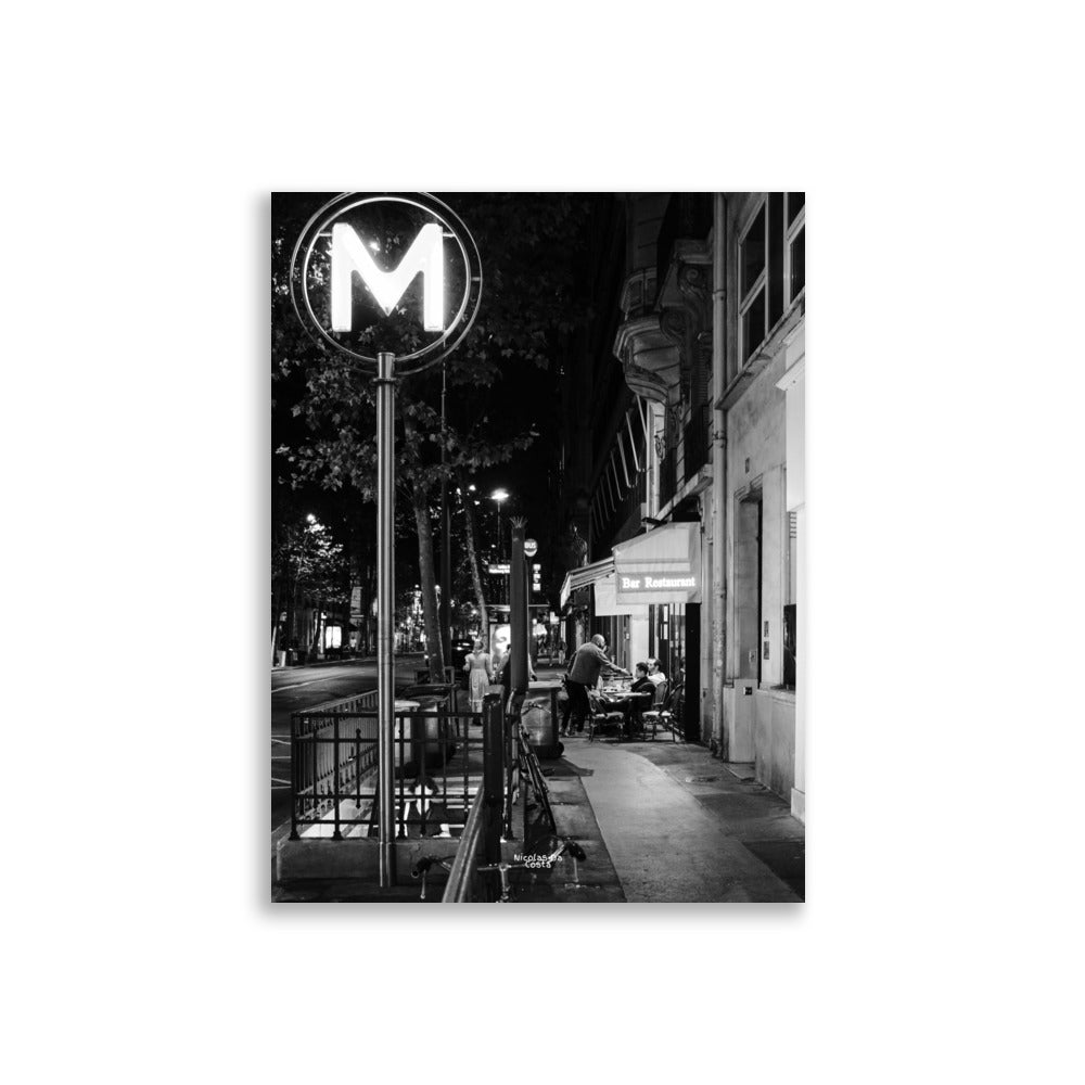 Photographie de rue en noir et blanc de "Rendez-vous Nocturne", capturant une scène de terrasse de café nocturne.