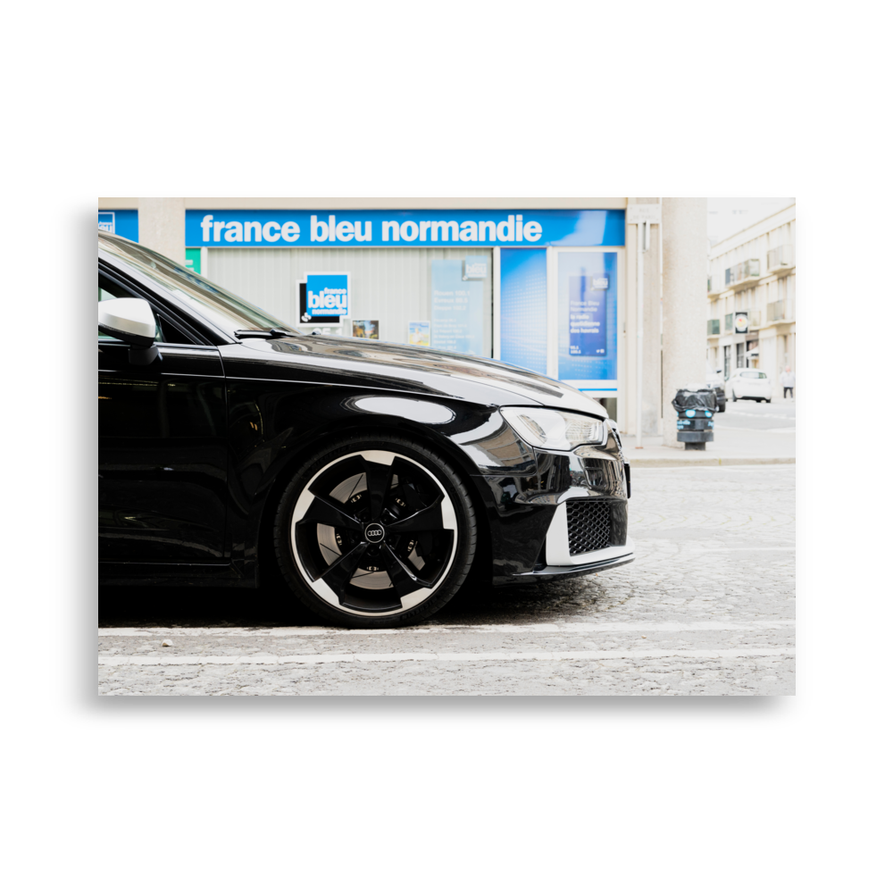 Poster en gros plan d'une Audi RS3 noire, vue de profil dans une rue du Havre