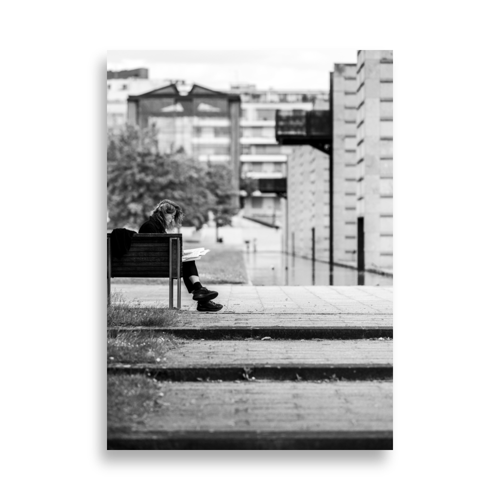 Dame lisant un livre sur un banc du Parc André Citroën, Paris.