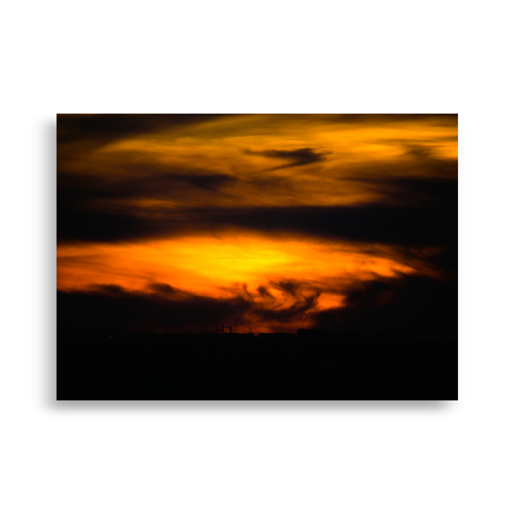 Coucher de soleil mêlé à des nuages très sombres, créant une impression de tempête dans le ciel.