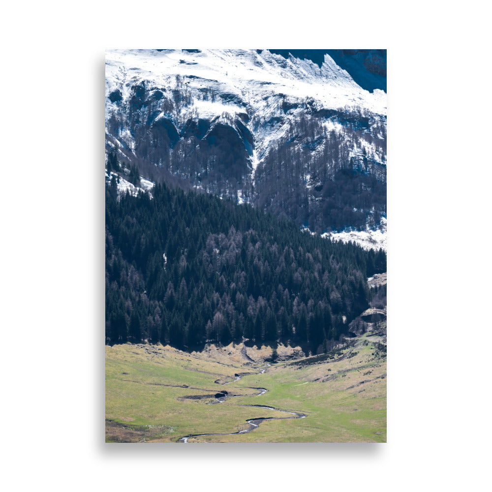 Photographie du paysage majestueux du Puy Mary en Auvergne, montrant des sommets enneigés et une vallée verdoyante.