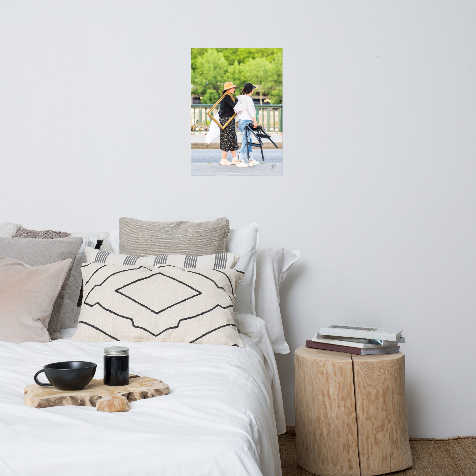 Photographie de deux femmes dans une rue, l'une portant élégamment un cadre en bois, évoquant mystère et art dans le quotidien.