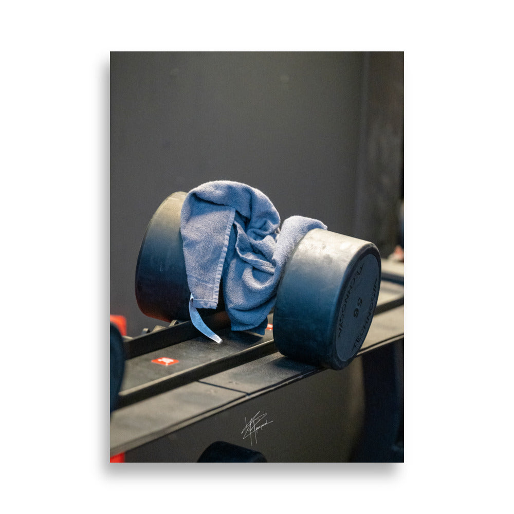 Photographie mettant en avant un poids de 56kg et une serviette, symbolisant la détermination et l'effort dans le fitness.