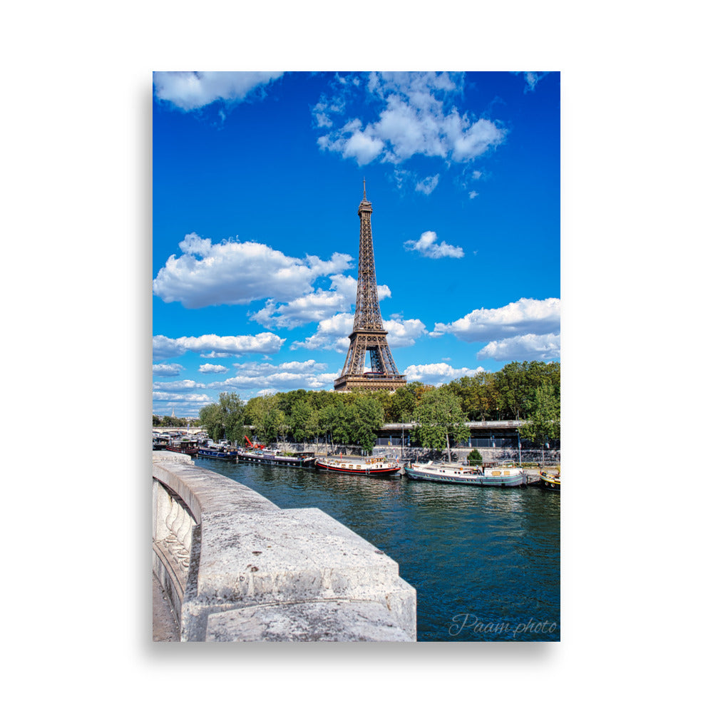 Vue panoramique de la Tour Eiffel et des péniches sur la Seine, sous un ciel bleu nuageux – une œuvre signée Antony Porlier.