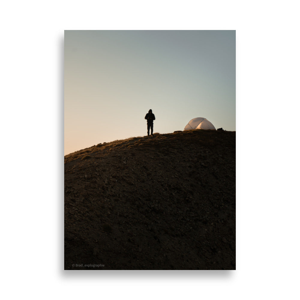 Randonneur face à l'aube, à côté de sa tente, sur une colline, capturé par Brad_explographie.