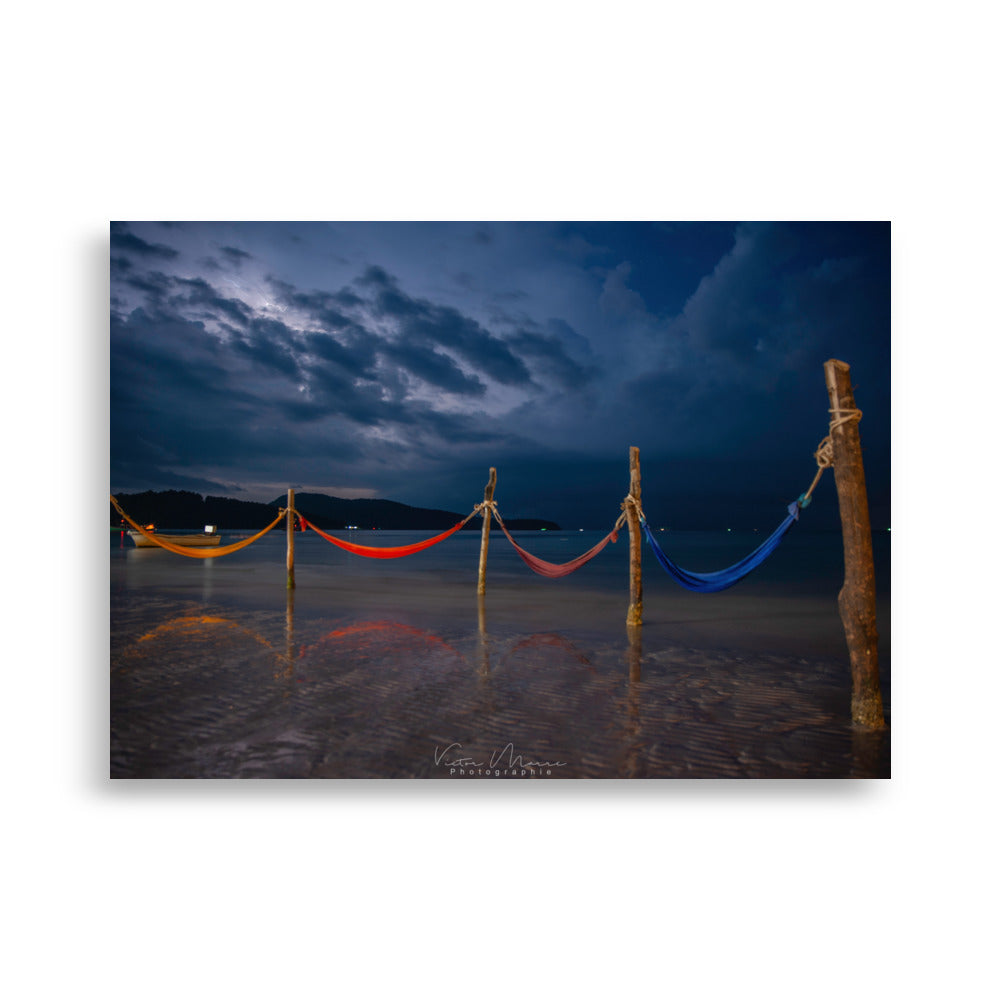 Poster 'Night amok', dépeignant une scène nocturne paisible d'éclats de tissus colorés, s’étirant depuis des branches jusqu'à l’océan calme sous un ciel nuageux, capturant une essence de sérénité et de mystère.