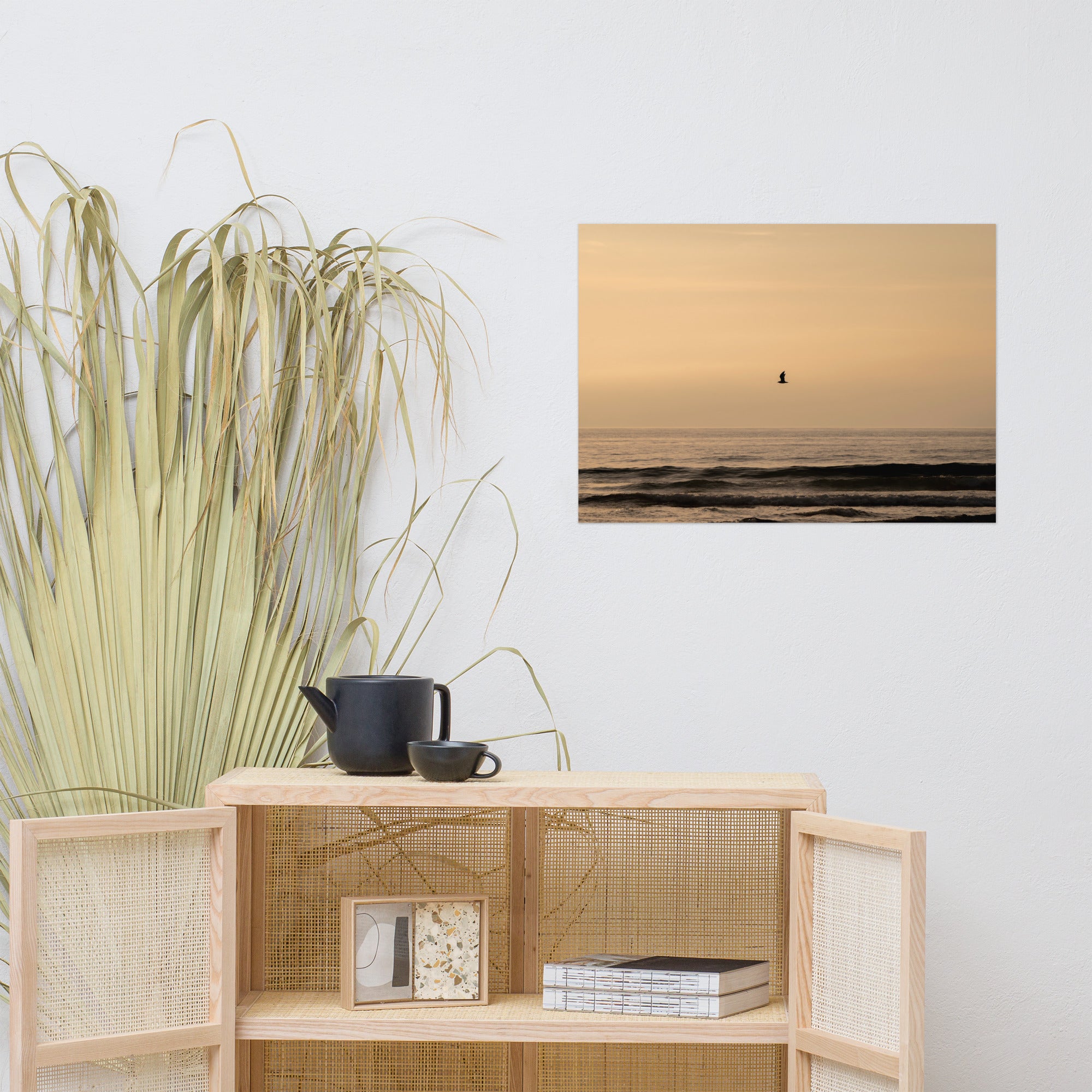 Photographie d'un coucher de soleil en bord de mer avec reflet du soleil sur les vagues, horizon doré et oiseau volant au-dessus de la mer.