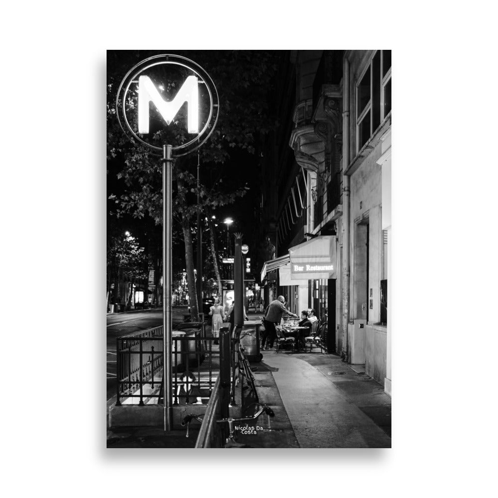 Photographie de rue en noir et blanc de "Rendez-vous Nocturne", capturant une scène de terrasse de café nocturne.