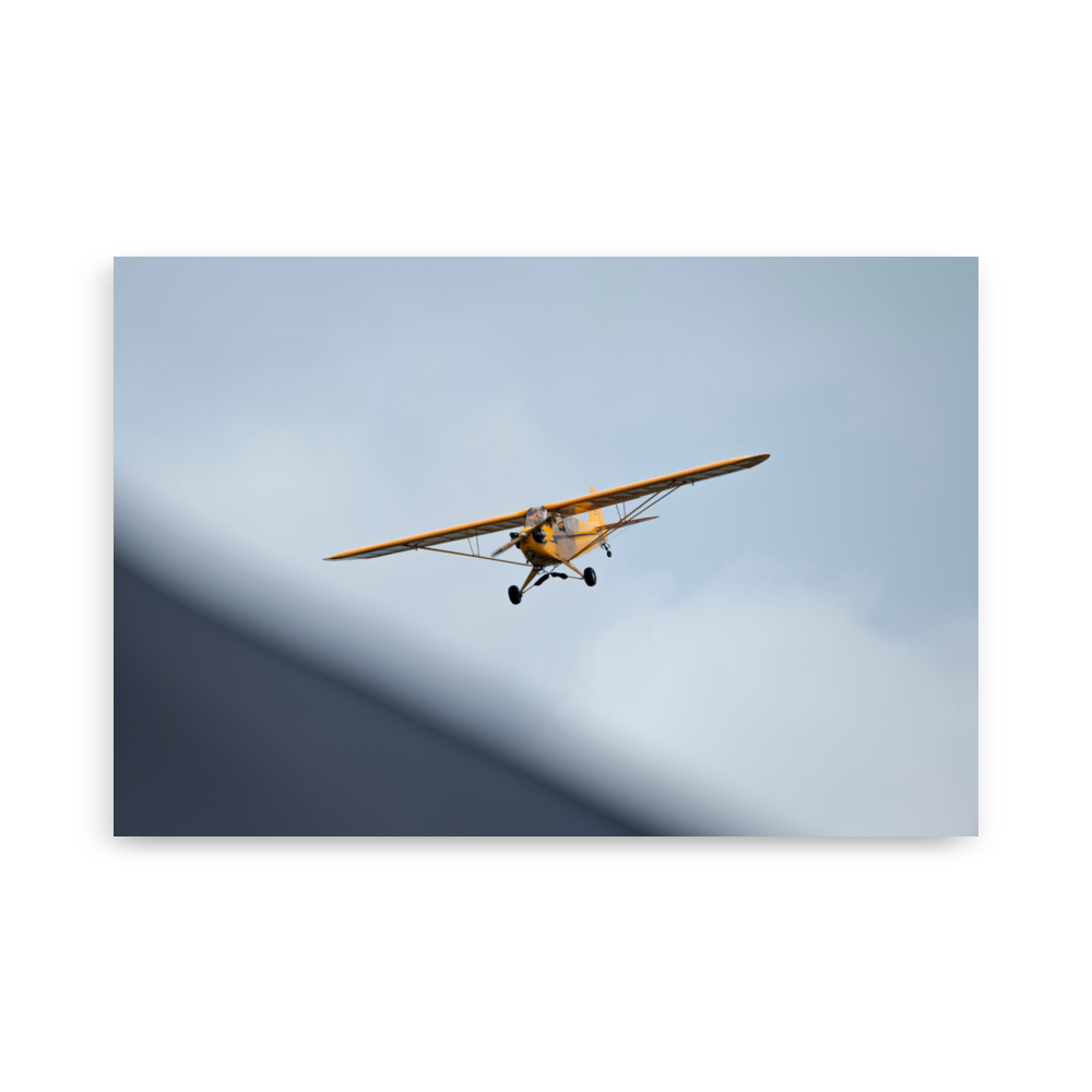 Photographie d'un Piper Cub jaune en plein vol.
