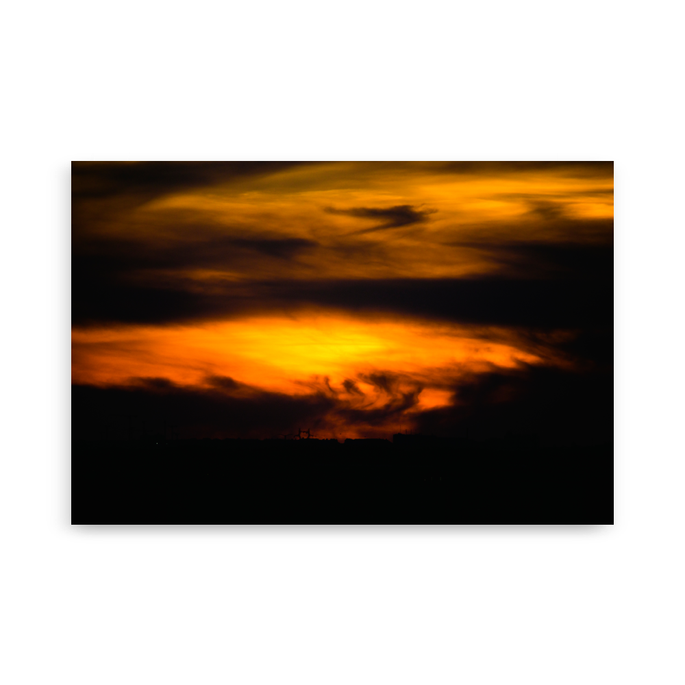 Coucher de soleil mêlé à des nuages très sombres, créant une impression de tempête dans le ciel.