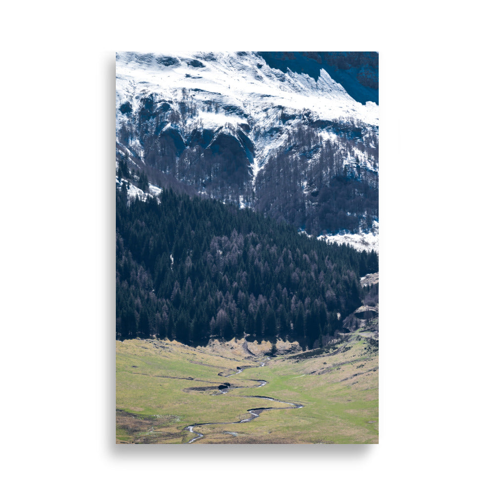Photographie du paysage majestueux du Puy Mary en Auvergne, montrant des sommets enneigés et une vallée verdoyante.