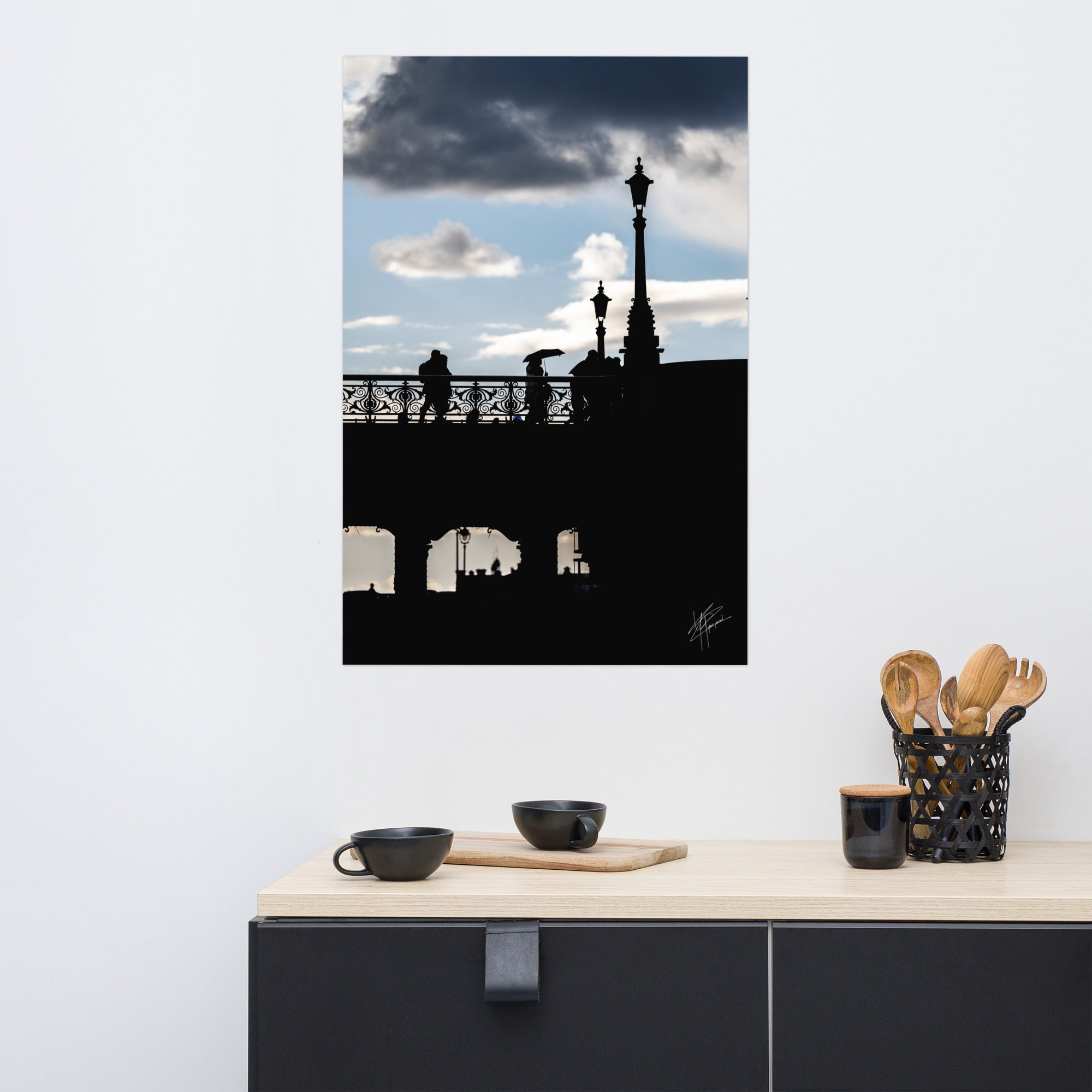 Des passants sur un pont parisien avec un ciel azur en arrière-plan, orné de nuages blancs et gris.