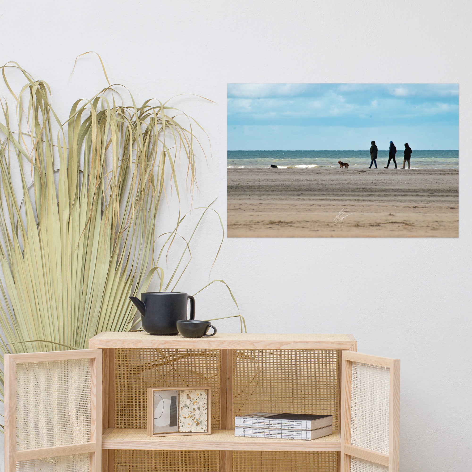 Photographie de la plage de Deauville avec des promeneurs et leur chien, capturant l'atmosphère tranquille et l'immensité de la mer normande.