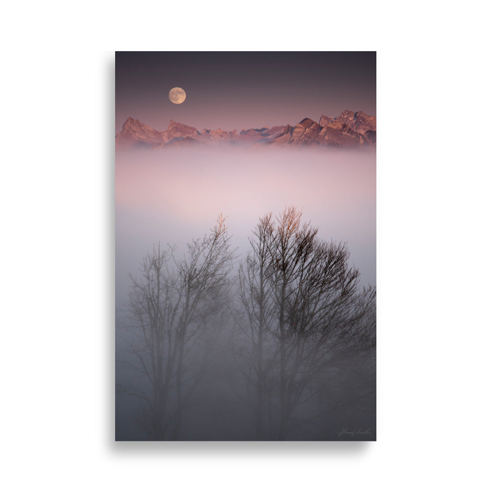 Deux arbres émergeant d'un brouillard mystique avec des montagnes lointaines et une lune radieuse en arrière-plan, une œuvre signée Florian Vaucher.