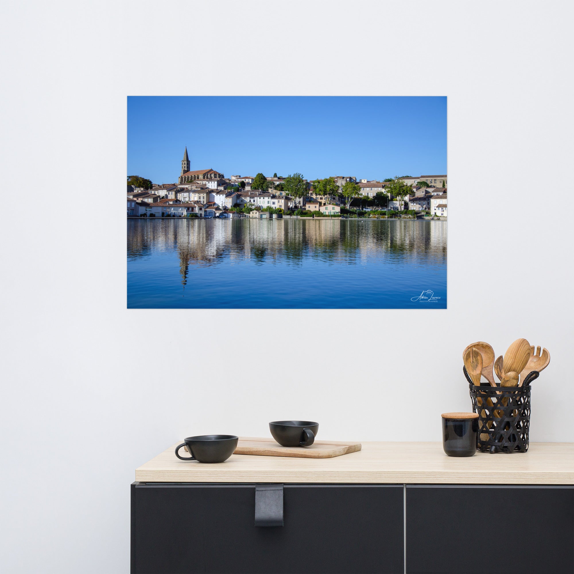 Poster 'Cœur de Castelnaudary', illustrant une scène paisible du bord du Canal du Midi avec des maisons charmantes, une église en arrière-plan, et une ambiance douce et pittoresque de la ville célèbre pour sa gastronomie.