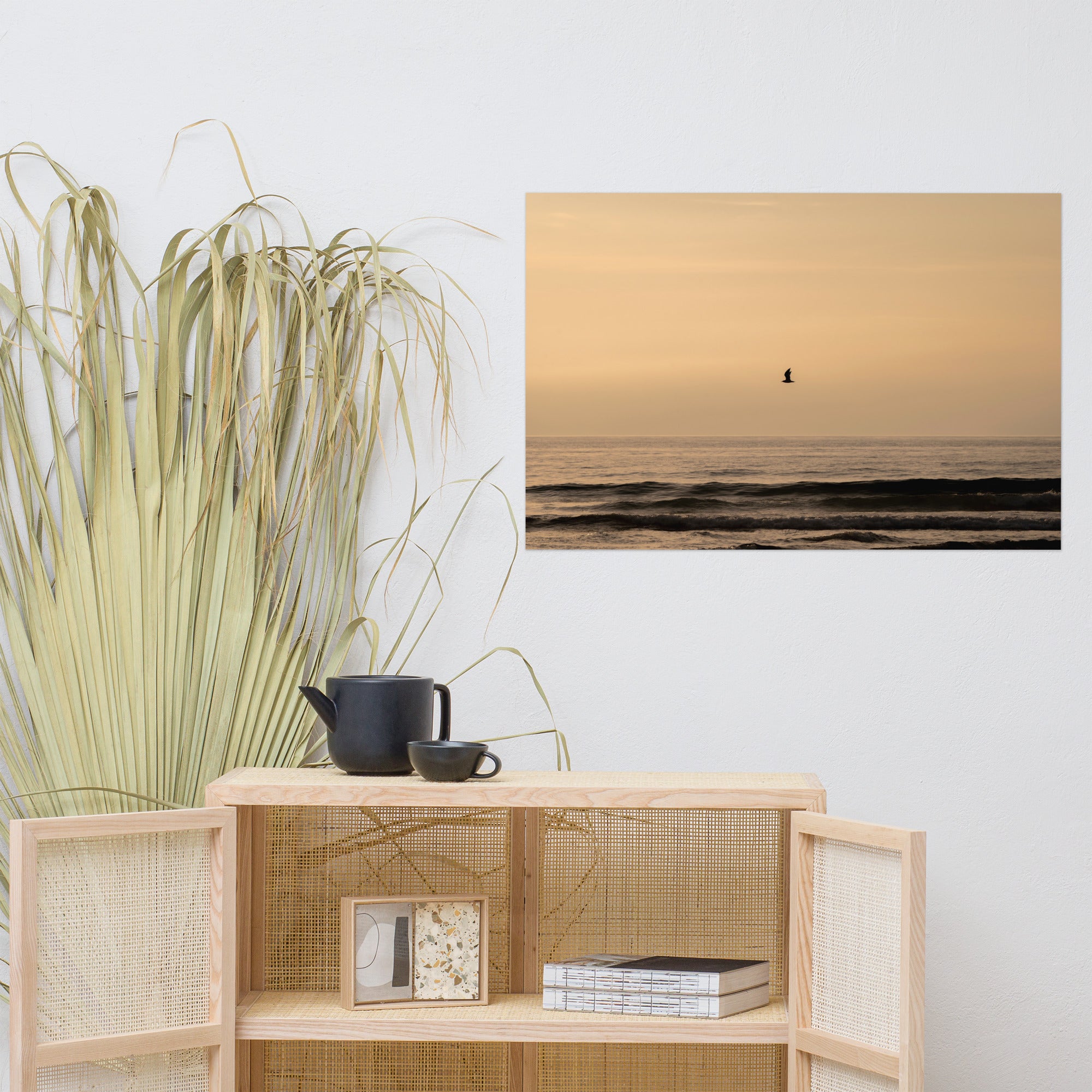 Photographie d'un coucher de soleil en bord de mer avec reflet du soleil sur les vagues, horizon doré et oiseau volant au-dessus de la mer.