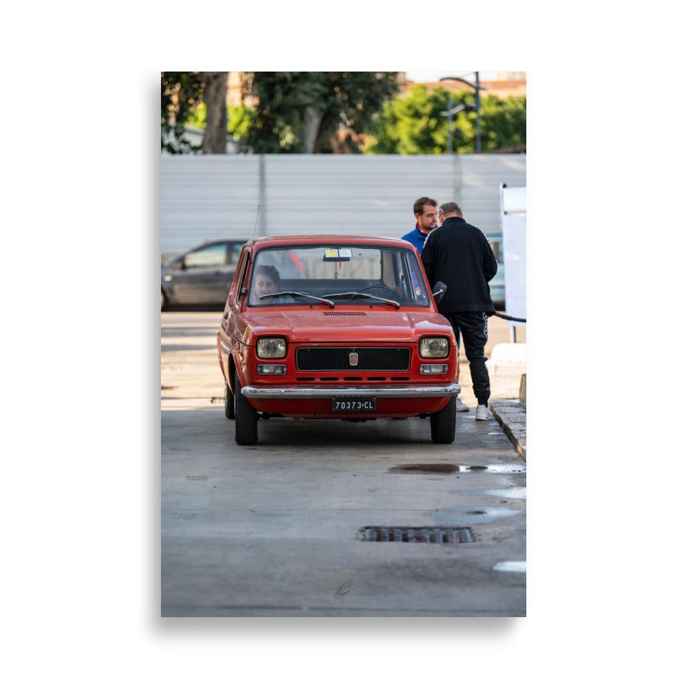 Poster "Nostalgie Urbaine" de Yann Peccard, montrant une voiture classique rouge dans une rue urbaine.