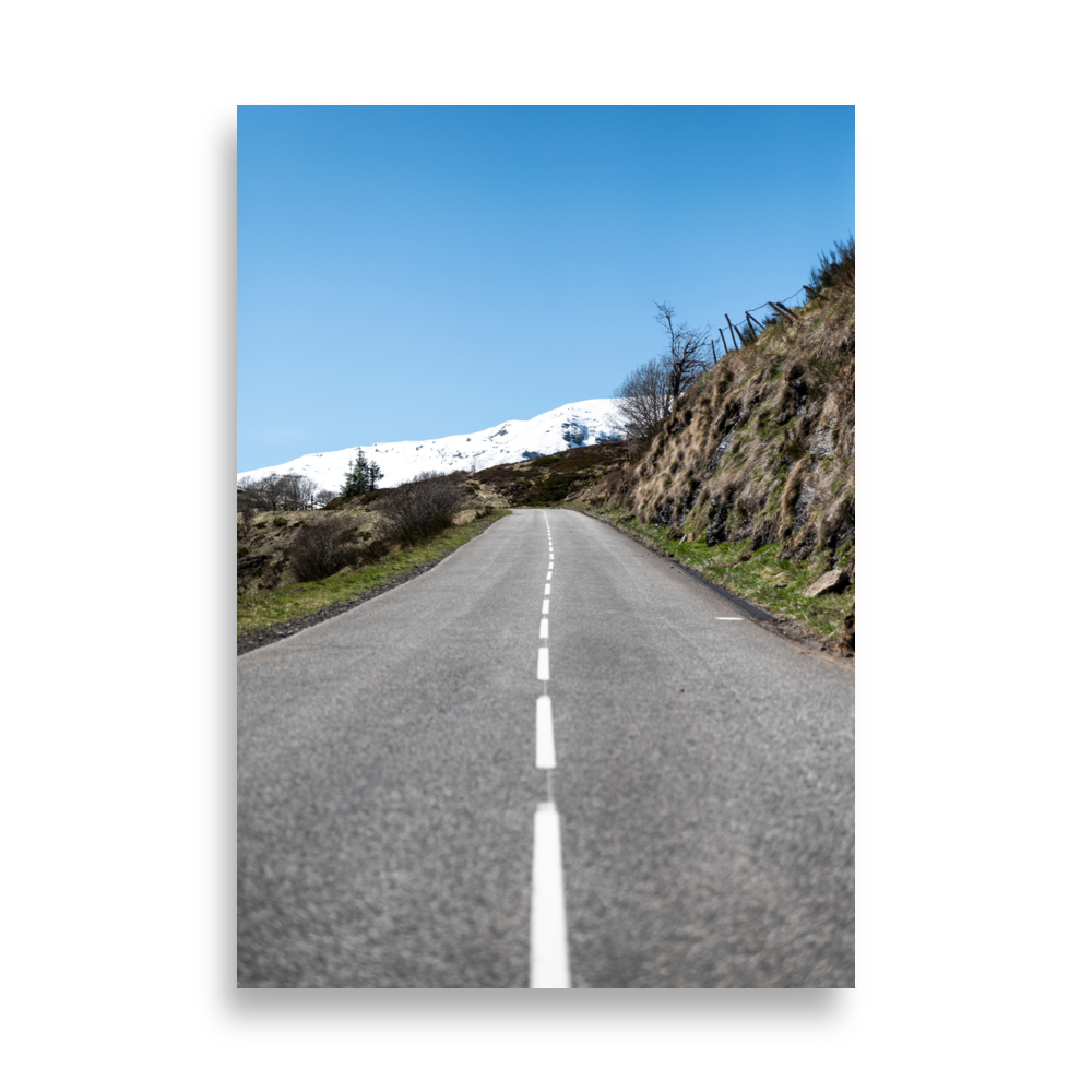 Photographie de route rurale menant à une montagne enneigée sous un ciel bleu dans le Cantal - Poster de paysage du Cantal