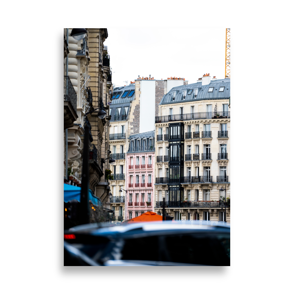 Petit bâtiment rose entre les grandes constructions à Paris.