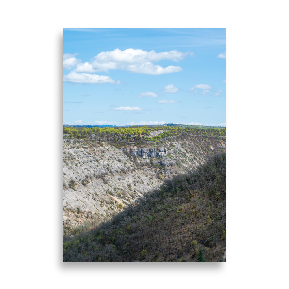 Vallée sèche avec arbres verts en haut et désert aride en bas, coupée en deux par la lumière du soleil.