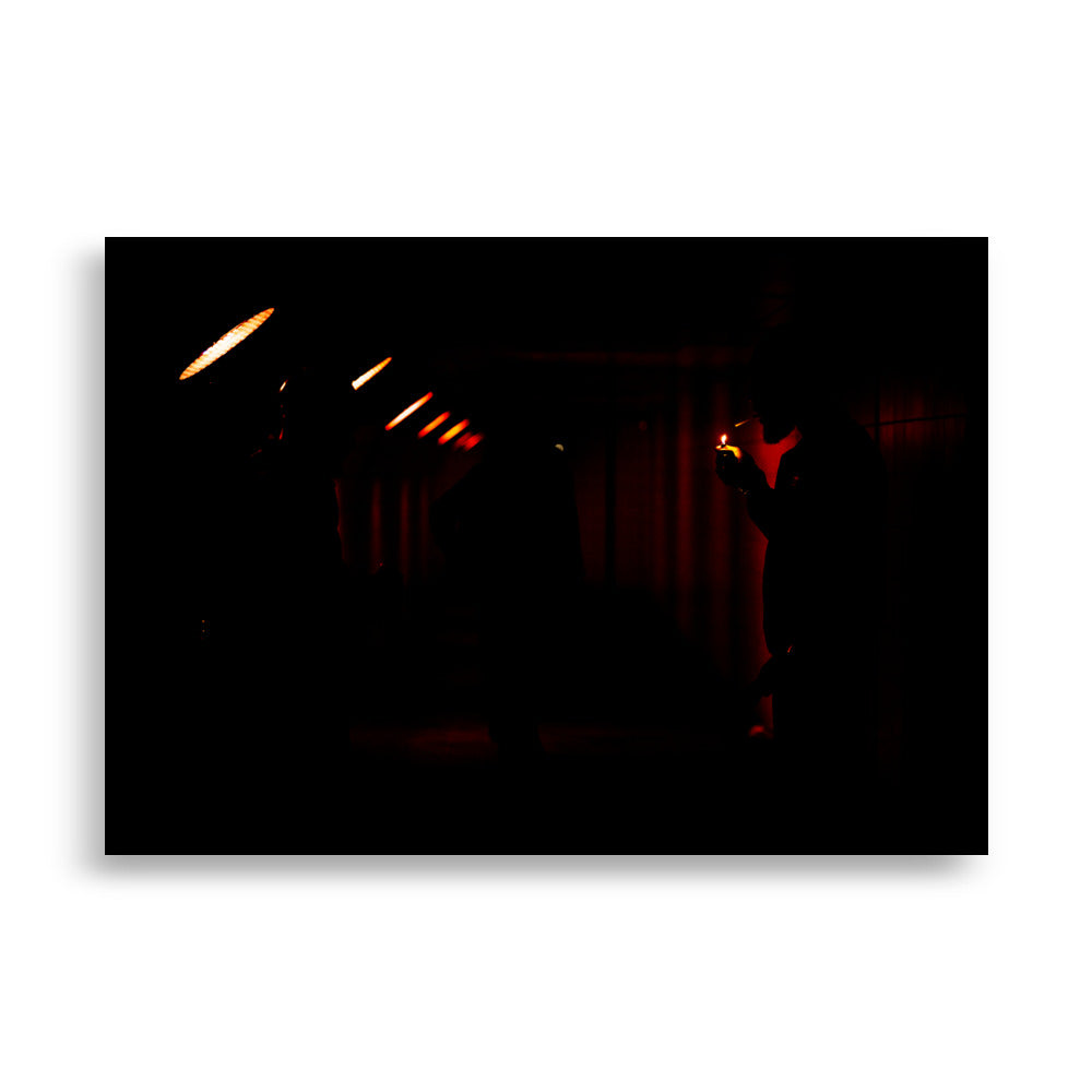 Poster 'Lueur dans l'Obscurité' d'un homme allumant sa cigarette dans un tunnel éclairé en rouge