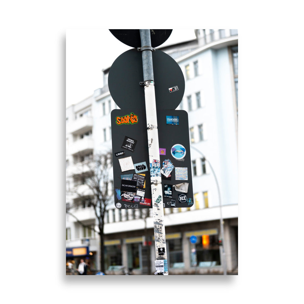 Photographie 'Liebe' dépeignant l'arrière des panneaux de circulation à Berlin couverts d'autocollants avec divers messages.