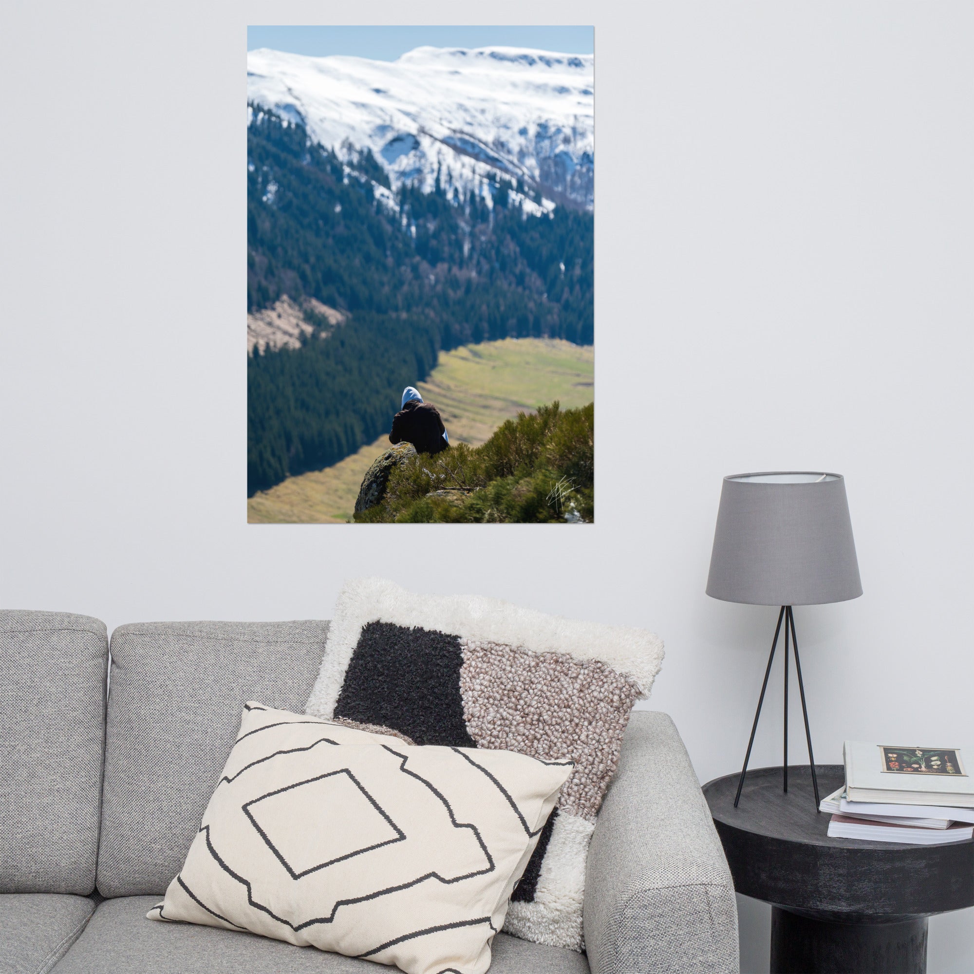 Figure en méditation sur une montagne du Cantal, vaste paysage en arrière-plan.