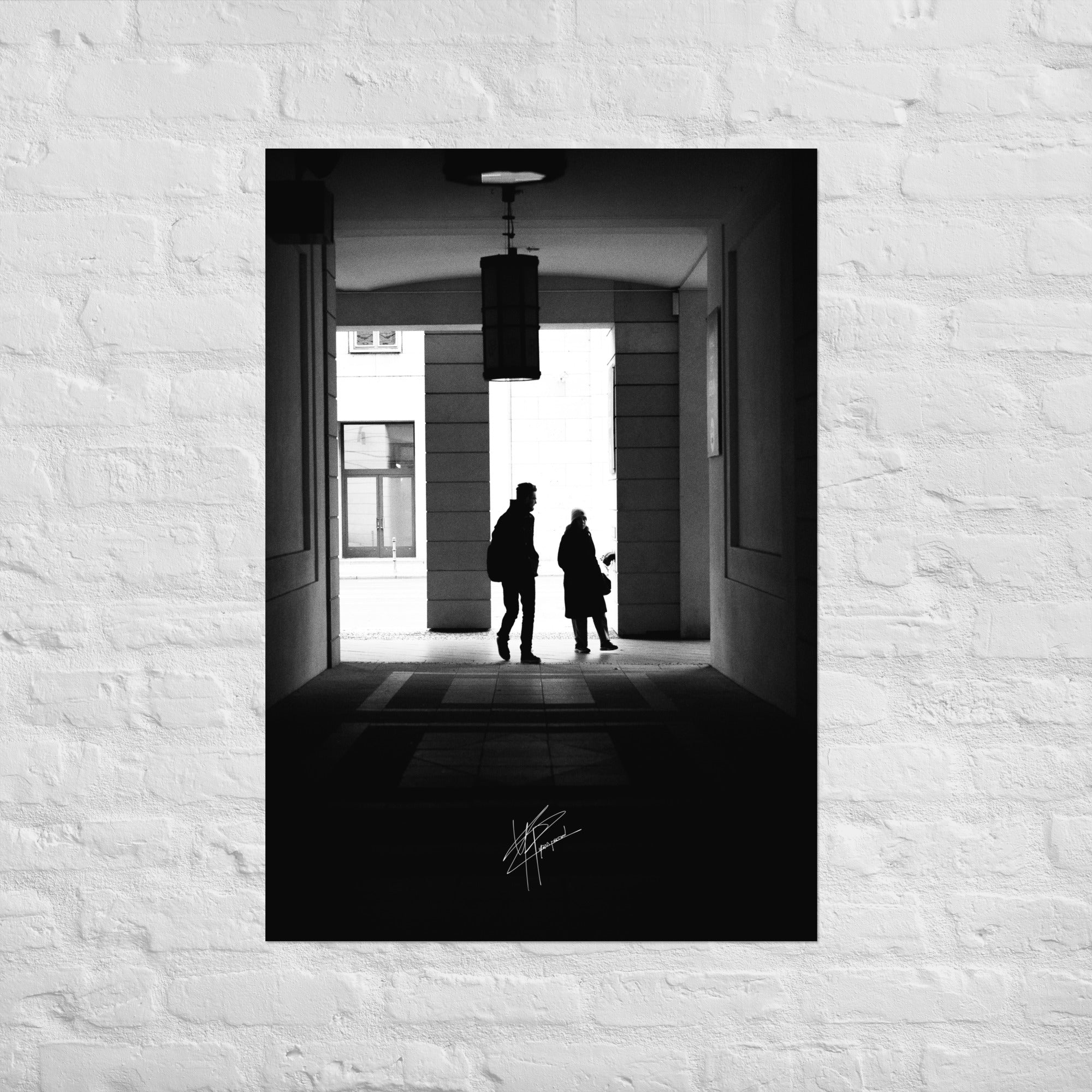 Une allée de Berlin en noir et blanc avec un couple marchant vers une lumière douce.
