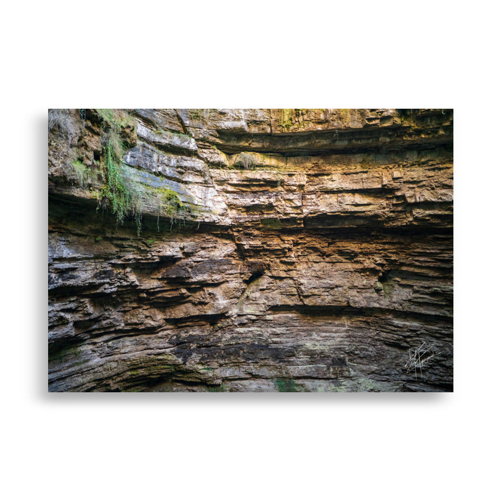 Photographie détaillée d'un mur de roche souterrain au gouffre de Padirac montrant des couches distinctes et des signes d'érosion.