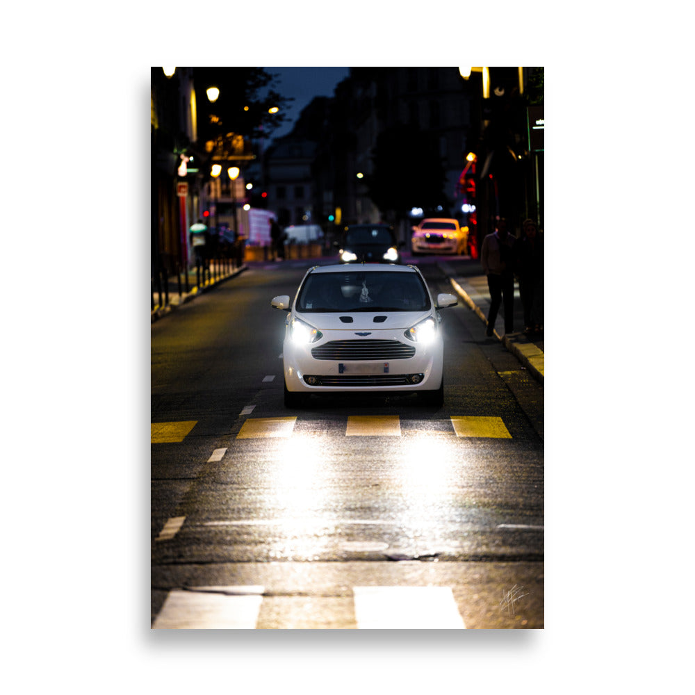 Vue de l'Aston Martin Cygnet, voiture de ville élégante, avec son design raffiné et son logo emblématique, positionnée contre un arrière-plan neutre pour mettre en valeur sa silhouette distincte.