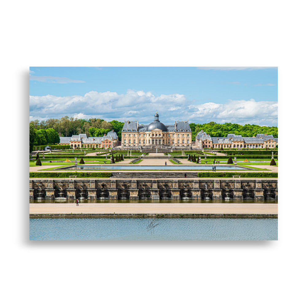 Photographie du Château de Vaux-le-Vicomte sous un ciel clair, mettant en valeur ses jardins impeccables et sa majestueuse architecture du XVIIe siècle.