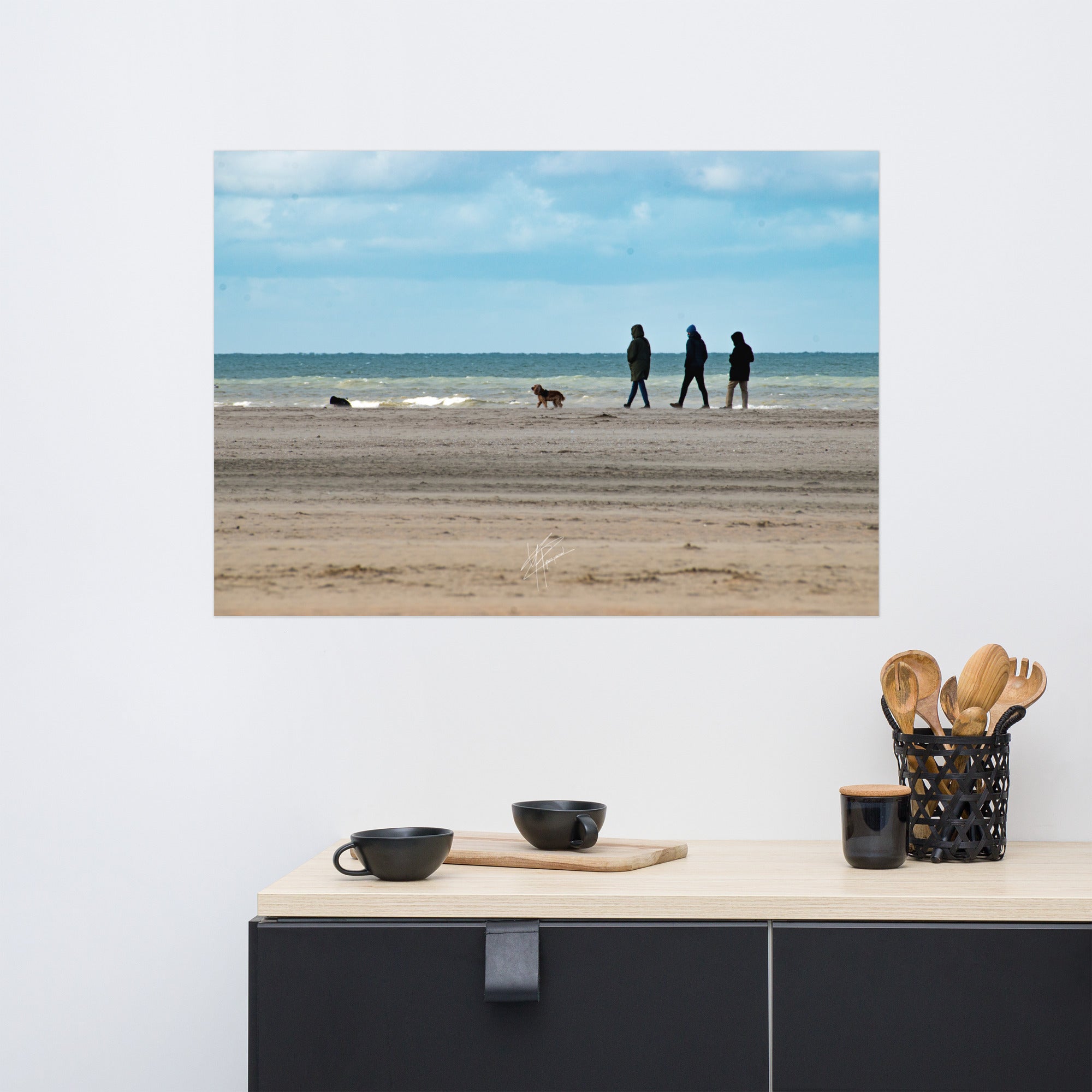 Photographie de la plage de Deauville avec des promeneurs et leur chien, capturant l'atmosphère tranquille et l'immensité de la mer normande.