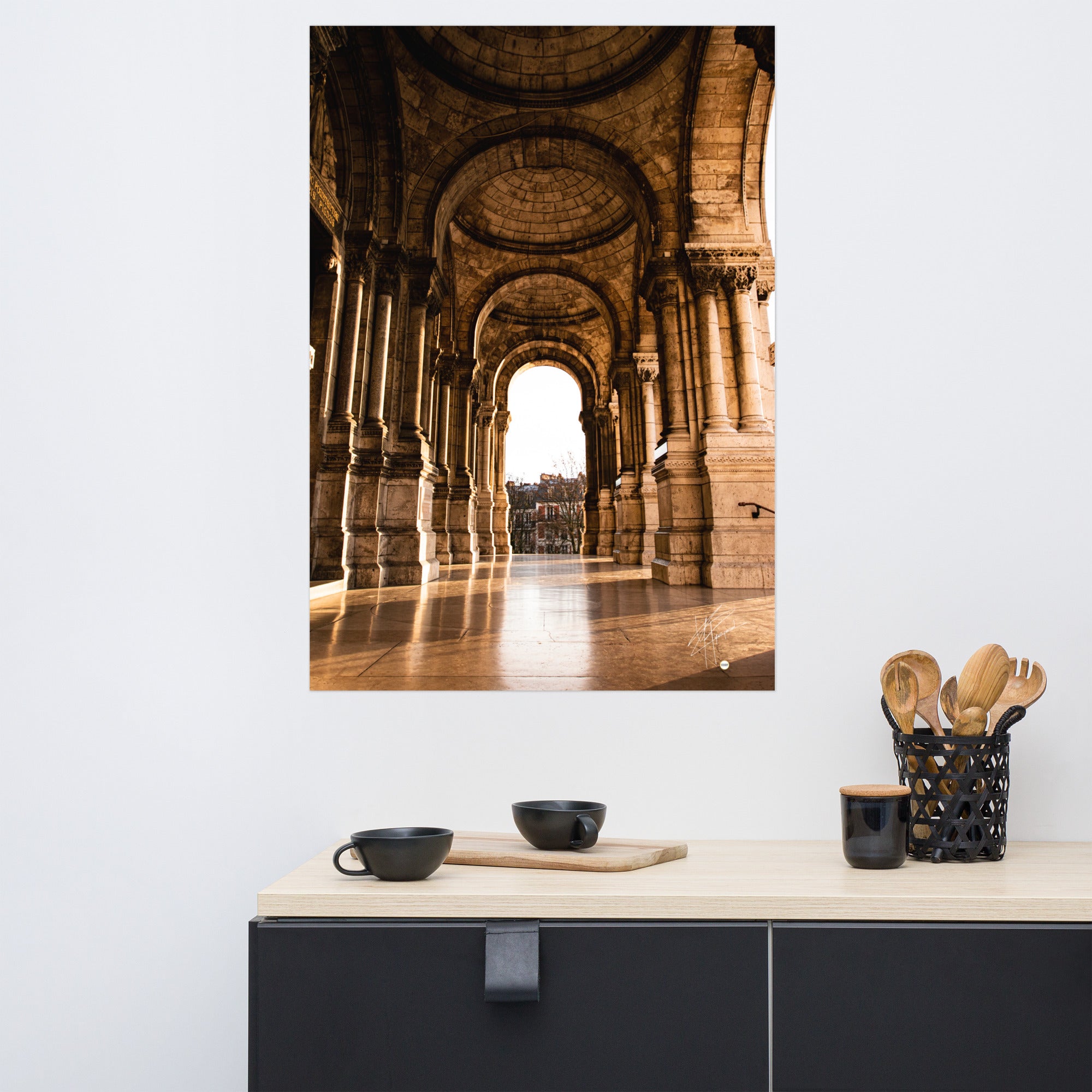 Photographie ensoleillée de la façade de l'entrée de la Basilique du Sacré Cœur à Montmartre, montrant l'architecture détaillée avec des reflets lumineux sur le sol pavé.