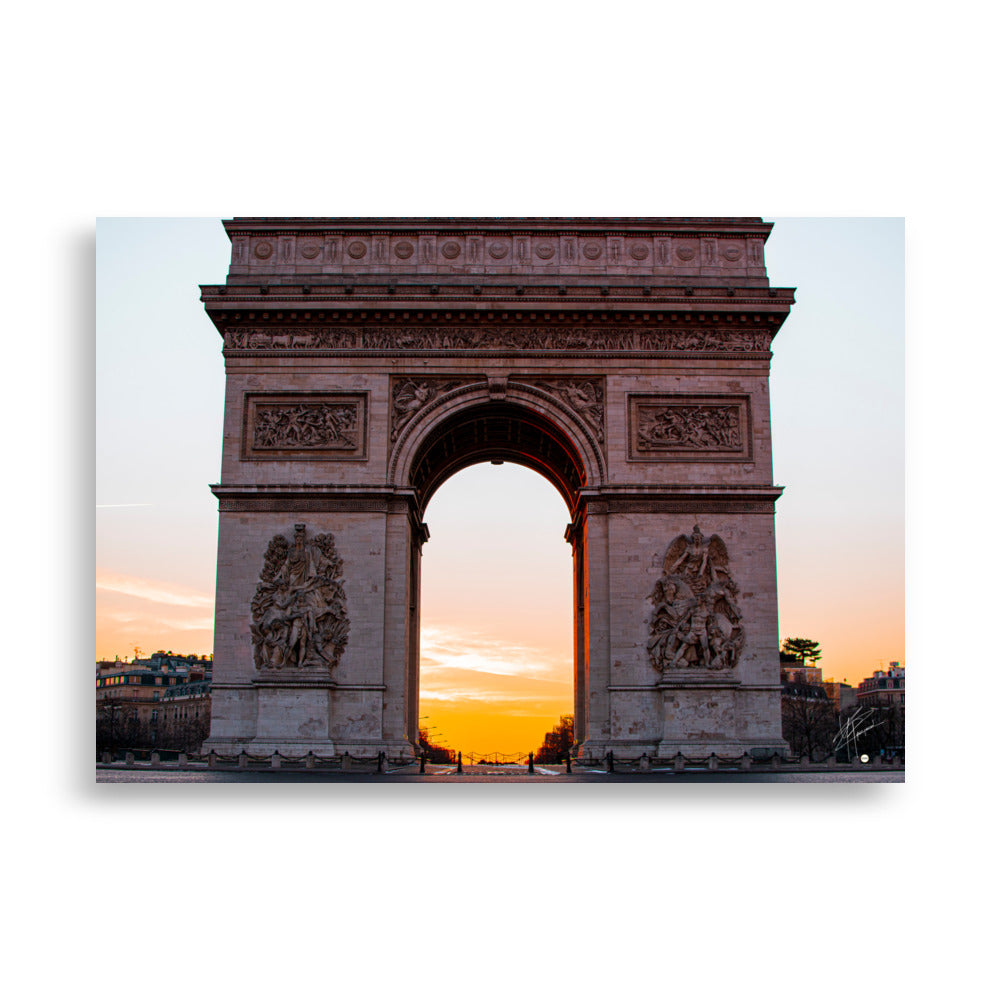 L'Arc de Triomphe de Paris au lever du soleil, ses contours majestueux se découpant contre un ciel orangé, symbolisant la gloire et l'espoir d'une nouvelle journée.