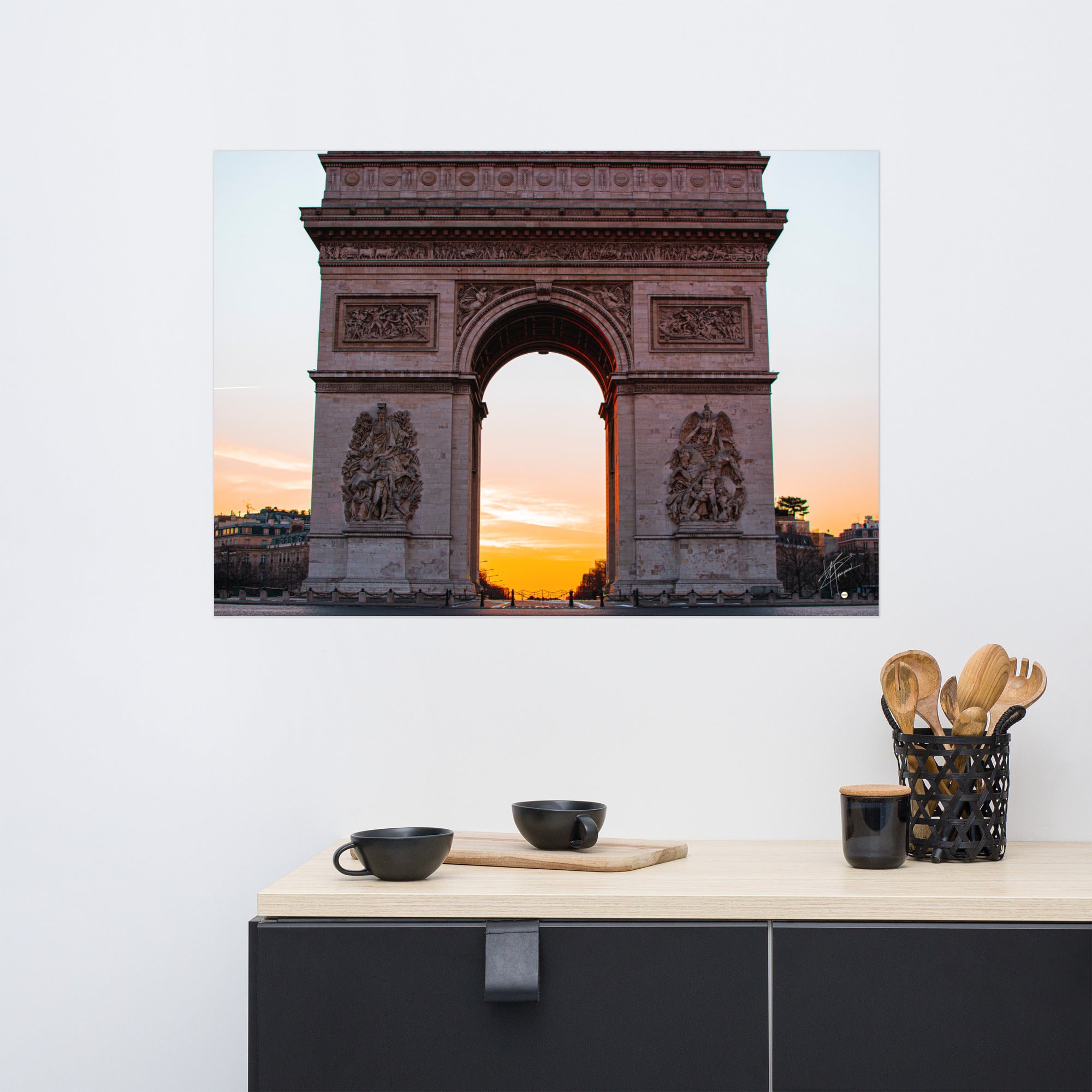 L'Arc de Triomphe de Paris au lever du soleil, ses contours majestueux se découpant contre un ciel orangé, symbolisant la gloire et l'espoir d'une nouvelle journée.