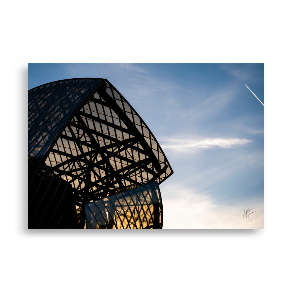 Bâtiment contemporain de la Fondation Louis Vuitton, avec ses voiles de verre et ses structures futuristes, sous un ciel bleu lumineux.